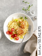 Couscous with chicken patties, cutlets and tomatoes, top down view. Стоковое фото, агентство Ingram Publishing / Фотобанк Лори