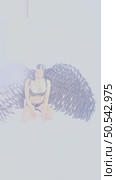 Woman poses with intricate wings in a studio setting for a beauty shoot. Стоковое видео, видеограф Гурьянов Андрей / Фотобанк Лори