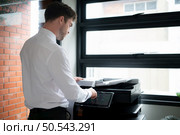 Businessman in office working with copier. Стоковое фото, агентство Ingram Publishing / Фотобанк Лори