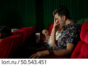 When watching scary ghost movies in theaters, moviegoers appear terrified. Стоковое фото, агентство Ingram Publishing / Фотобанк Лори