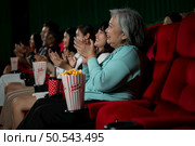 Family members of an Asian senior woman clap their hands for the movies she watches with the impression. Стоковое фото, агентство Ingram Publishing / Фотобанк Лори