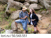 Young couple hiking in the forest with backpacks and trekking poles. Стоковое фото, агентство Ingram Publishing / Фотобанк Лори