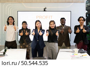 A group of multiracial businesspeople gives the thumbs up in front of the meeting room, indicating the concept of business success. Стоковое фото, агентство Ingram Publishing / Фотобанк Лори