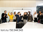 A group of multiracial businesspeople hands raise to celebrate success in front of the meeting room, indicating the concept of business success. Стоковое фото, агентство Ingram Publishing / Фотобанк Лори