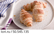 Small croissants in white ceramic plates, homemade cakes on concrete table top. Стоковое фото, агентство Ingram Publishing / Фотобанк Лори