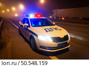 Экипаж ДПС ГАИ патрулирует на ночной трассе. Тraffic police car checks a vehicle on a night highway. (2024 год). Редакционное фото, фотограф Станислав Самойлов / Фотобанк Лори