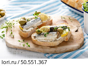 Sardines sandwiches on a white wooden background. Mediterranean food. Стоковое фото, агентство Ingram Publishing / Фотобанк Лори