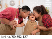 A plus-size family with a father wearing a prosthetic leg, Eat together after cooking and daughter drinks milk for health in the dining room of the house. Стоковое фото, агентство Ingram Publishing / Фотобанк Лори