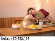 A plus-size family with a father wearing a prosthetic leg, Eat together after cooking and daughter drinks milk for health in the dining room of the house. Стоковое фото, агентство Ingram Publishing / Фотобанк Лори