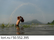 Fishermen using traditional fishing equipment After catching fish, clean up and play in the water. Стоковое фото, агентство Ingram Publishing / Фотобанк Лори