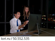 Both of young Asian broker international stock traders working together on desktop at night office, International financial investment company concept. Стоковое фото, агентство Ingram Publishing / Фотобанк Лори