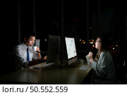 Both of young Asian broker international stock traders working together on desktop at night office, International financial investment company concept. Стоковое фото, агентство Ingram Publishing / Фотобанк Лори