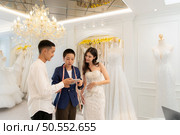 Bridal gown designers and tailors measure the size of the gown against the bride’s figure when she comes to try on the gown in order to make it perfect and ready to wear on the wedding day. Стоковое фото, агентство Ingram Publishing / Фотобанк Лори