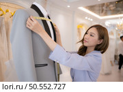 Asian fashion designers make sure the groom’s outfit is absolutely accurate and ready for the bride and groom to try on. Стоковое фото, агентство Ingram Publishing / Фотобанк Лори