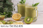 Glasses of green vegetable smoothie. Green vegetable smoothie and ingredients: Kiwi, lemon and herbs. Стоковое фото, агентство Ingram Publishing / Фотобанк Лори