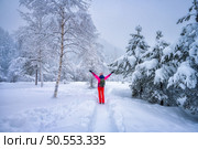 Happy young woman with backpack and raised up arms in fairy snowy forest in winter. Kranjska Gora, Slovenia. Trees in snow, hoar, sporty girl, trail. Snowfall in foggy woods. Wintry woodland. Hiking. Happy woman with backpack in fairy snowy forest in winter. Стоковое фото, агентство Ingram Publishing / Фотобанк Лори