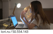A young woman works on her laptop at home. It is characterized with headaches that occur when stressed. Стоковое фото, агентство Ingram Publishing / Фотобанк Лори