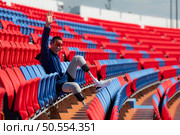 Disabled athletes prepare their bodies on amphitheater in a sports arena on a sunny day before entering a short-distance running competition. Стоковое фото, агентство Ingram Publishing / Фотобанк Лори