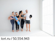 A group of female and male athletes stood and chatted amicably in the studio before beginning with the yoga class. Стоковое фото, агентство Ingram Publishing / Фотобанк Лори