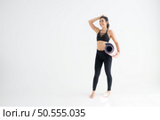 Full length portrait of a young woman holding yoga mat isolated on white background. Стоковое фото, агентство Ingram Publishing / Фотобанк Лори