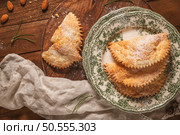 A crescent-shaped pastry whose filling is made of eggs and almonds wrapped in crispy dough, cut in an artisanal way and sprinkled with sugar. Стоковое фото, агентство Ingram Publishing / Фотобанк Лори