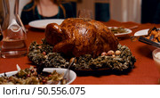 Roasted turkey garnished with cranberries on a rustic style table decoraded with pumpkins, gourds, asparagus, brussel sprouts, baked vegetables, pie, flowers, and candles. Стоковое фото, агентство Ingram Publishing / Фотобанк Лори