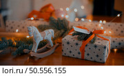 Christmas or Newyear gift box with tree branches and christmas decorations on wooden table, twinkling party lights bokeh background. Стоковое фото, агентство Ingram Publishing / Фотобанк Лори