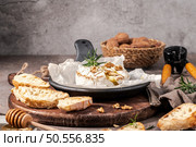 Brie type of cheese. Camembert cheese. Fresh sliced Brie cheese on a wooden tray with nuts, honey and leaves. Italian, French cheese. Стоковое фото, агентство Ingram Publishing / Фотобанк Лори