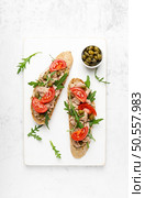 Tuna caper toasts with arugula, tomatoes and whole rye bread, top view. Стоковое фото, агентство Ingram Publishing / Фотобанк Лори
