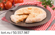 Italian food, pizza calzone with tomato, spinach and cheese on wooden background. Стоковое фото, агентство Ingram Publishing / Фотобанк Лори