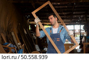 Carpenter working at his carpentry shop. Eyesight is utilized to ensure accuracy. Стоковое фото, агентство Ingram Publishing / Фотобанк Лори