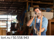 Carpenter working at his carpentry shop. Eyesight is utilized to ensure accuracy. Стоковое фото, агентство Ingram Publishing / Фотобанк Лори