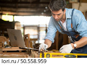 Carpenter working at his carpentry shop. Eyesight is utilized to ensure accuracy. Стоковое фото, агентство Ingram Publishing / Фотобанк Лори