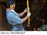 Portrait of a carpenter holding a spirit level in his workshop. Стоковое фото, агентство Ingram Publishing / Фотобанк Лори
