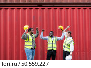 Group of workers in a container storage yard greeting each other during breaks in front of container warehouse, Стоковое фото, агентство Ingram Publishing / Фотобанк Лори