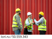 Group of workers in a container storage yard greeting each other during breaks in front of container warehouse, Стоковое фото, агентство Ingram Publishing / Фотобанк Лори