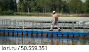 Technician currently evaluating and repairing the transmission terminals for electricity generated by solar energy in a floating solar power system. Стоковое фото, агентство Ingram Publishing / Фотобанк Лори