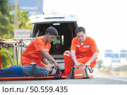 The paramedic  is assisting an injured man in an emergency situation on the road. Стоковое фото, агентство Ingram Publishing / Фотобанк Лори