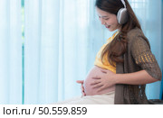 Pregnant mothers enjoy listening to music with their unborn children. Стоковое фото, агентство Ingram Publishing / Фотобанк Лори