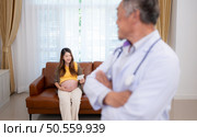Portrait of obstetrician gynecologist, Asian pregnant woman visit gynecologist doctor at medical clinic for pregnancy consultant. Стоковое фото, агентство Ingram Publishing / Фотобанк Лори