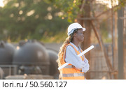 At the building site, a female engineer holds a blueprint in hand. Стоковое фото, агентство Ingram Publishing / Фотобанк Лори