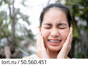 Portrait of a young asian woman with braces on her teeth. Стоковое фото, агентство Ingram Publishing / Фотобанк Лори