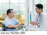 In the hospital office, A medical explains about the spine and its treatment to a patient. Стоковое фото, агентство Ingram Publishing / Фотобанк Лори