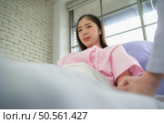 Female doctor with IV equipment will give IV fluids and examine patients lying in hospital beds. Стоковое фото, агентство Ingram Publishing / Фотобанк Лори