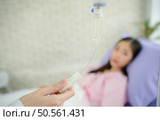 Female doctor with IV equipment will give IV fluids and examine patients lying in hospital beds. Стоковое фото, агентство Ingram Publishing / Фотобанк Лори