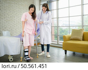 Following a period of treatment, the doctor examines the patient’s legs and knees. Стоковое фото, агентство Ingram Publishing / Фотобанк Лори