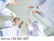 A delighted doctor team enjoying achievement in a hospital setting with clap hands. Стоковое фото, агентство Ingram Publishing / Фотобанк Лори