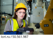 Female technician who maintains a small robot arm the operation of a small robot arm used in industry is being repaired. Стоковое фото, агентство Ingram Publishing / Фотобанк Лори