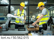 Group of engineers and technicians learning the technology to control hand robots for industrial usage. Стоковое фото, агентство Ingram Publishing / Фотобанк Лори