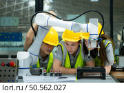 Group of engineers and technicians learning the technology to control hand robots for industrial usage. Стоковое фото, агентство Ingram Publishing / Фотобанк Лори